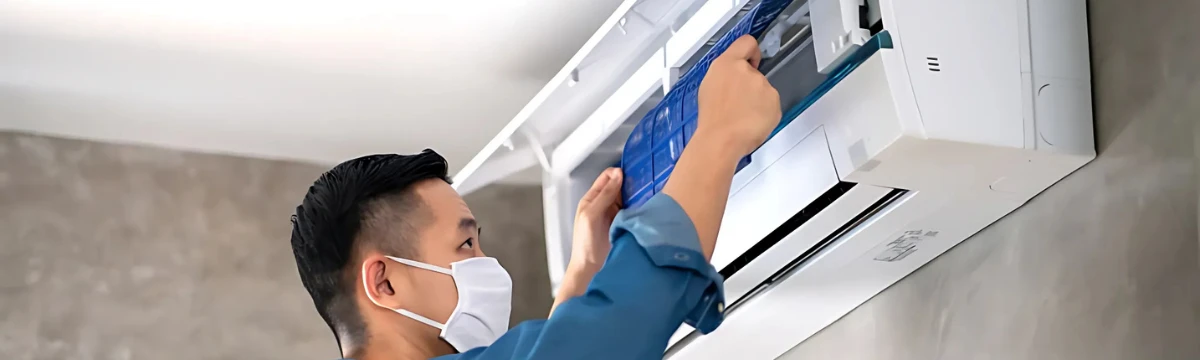 Kỹ thuật viên chuyên nghiệp đang sửa điều hòa treo tường tại nhà khách.